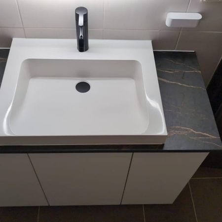 Modernes Waschbecken auf einer edlen Keramikplatte in Marmordesign.